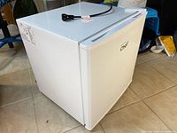Mini fridge closed showing exterior and power cord