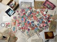 Overview of scattered loose stamps with envelopes and small box