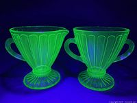 Both pieces glowing under UV light showing uranium content