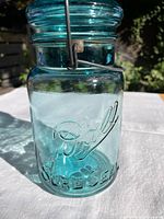 Front view of Ball Sure-Seal quart aqua jar showing embossed logo and bale