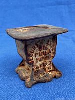 Overall view of cast iron weight showing shape and rusted finish