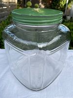 Front view of clear ribbed glass canister with green lid