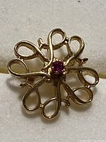 Front view showing floral scroll design and ruby centre