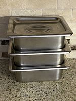 Stacked view of three pans with lids
