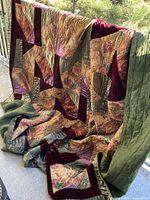 Full view of quilt draped over railing showing pattern and backing