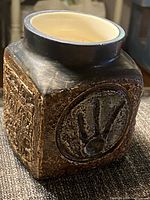 Front/right view showing square form, textured panel and dark rim