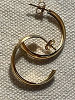 Both earrings lying on fabric, showing overall shape and size