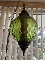 Full view of hanging green glass globe pendant lamp with chain