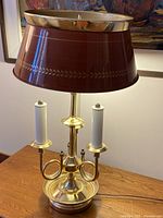 Front view showing brass lamp, burgundy shade, three sockets