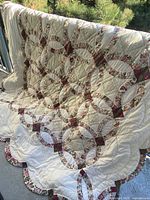 Front view showing full quilt with double wedding ring pattern and scalloped border
