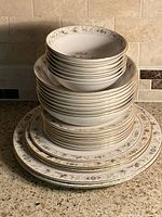 Stack of plates and bowls showing pattern and gold trim