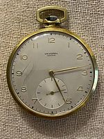 Front view of pocket watch showing dial, hands and crystal crack