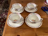 Four cups and four saucers grouped on table