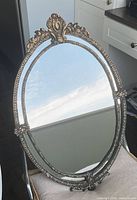 Full view of oval cast iron mirror on chair