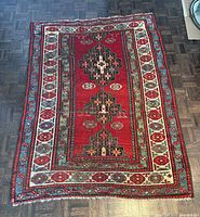 Full view of red geometric wool rug on floor