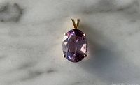 Front view showing oval amethyst and gold prong setting
