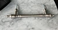 Full view of satin nickel handle lying flat showing both mounting posts and bolts