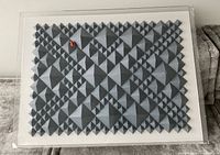 Full view of grey paper triangular relief artwork in acrylic frame