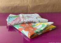 Both folded tablecloths showing floral prints