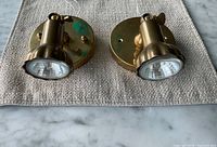 Front view of both brass spotlights on fabric mat