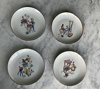 Top view of all four plates showing individual illustrations and gold rims