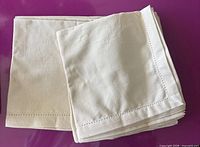 Stack of folded cream linen napkins
