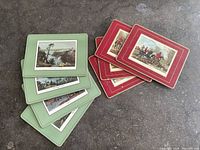 Stacked sets of red and green placemats showing artwork and colours