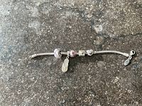 Full view of bracelet with five charms laid flat