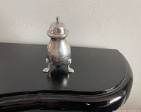 Full view of pepper pot assembled, showing three feet and lid
