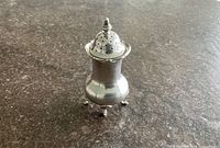 Full view of pepper pot showing feet, body shape and lid