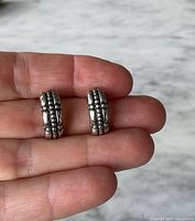 Front view of sterling silver half hoop earrings showing beaded design