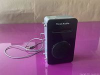 Front view showing Tivoli Audio logo, dock slot, speaker grille and attached cable