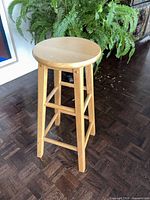 Full view of wooden stool standing upright