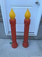 Two red blow mold NOEL candles with cords