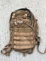Front view showing CamelBak logo, MOLLE webbing, compression straps