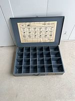 Open case showing plastic divider tray and chart