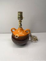 Full view of ceramic lamp showing glaze, handles, socket, cord