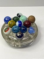 Overhead view showing all 13 marbles arranged in glass flower frog