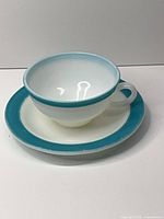 Cup on saucer full view showing turquoise rim