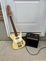 Front view of Dana guitar leaning on Darius 100 amp