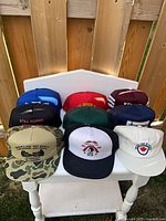 Group shot of all ten vintage trucker caps on chair