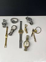 Group shot of all nine wristwatches arranged on table