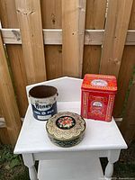 All three tins on white table for overview