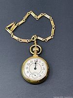 Front view of gold-tone pocket watch on chain