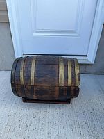 Side view of wooden barrel with metal bands on base