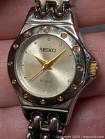 Front view of Seiko women's quartz wristwatch showing dial, bezel studs, crown