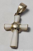Front view of sterling silver cross pendant showing white inlay and bail