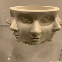 Front view of pedestal bowl showing four abstract faces