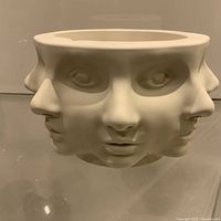 Front view of unglazed white multi-face pedestal bowl