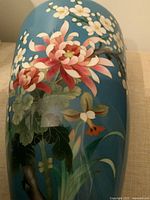 Side view showing floral enamel design on blue ground